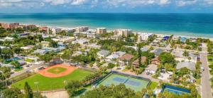 una vista aérea de un complejo con un campo de béisbol y el océano en Tropical Pelican Beach Home en Clearwater Beach