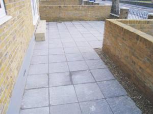 a patio with a bench next to a brick wall at 1 Bed Room Flat Near Central in London