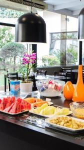 a table topped with plates of fruits and vegetables at Executivo em Hotel - Vila Olímpia in Sao Paulo