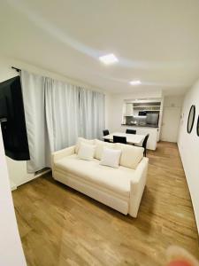 a living room with a white couch and a kitchen at NOTRE SOUL in Tigre