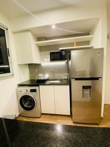 a kitchen with a refrigerator and a washing machine at NOTRE SOUL in Tigre