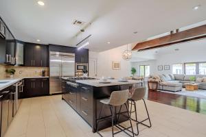 a kitchen with black cabinets and a kitchen island with bar stools at Exquisite Oasis near Universal Studios with Large Pool in Los Angeles