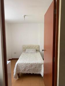 een slaapkamer met een bed in een witte kamer bij Casa por tecsup in Paucarpata
