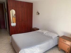 een slaapkamer met een bed, een dressoir en een spiegel bij Casa por tecsup in Paucarpata
