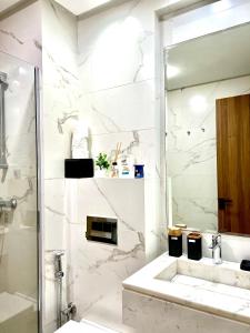 a white bathroom with a sink and a mirror at Rafina A12 in Casablanca