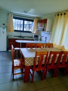 a kitchen with a table and some chairs and a table and a kitchen with at Cabañas L Calafquen in Licán Ray