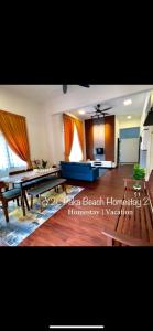 een woonkamer met een tafel en een blauwe bank bij CozyLuxury Homestay Paka 3-7pax near Paka Beach and surrounding many Restaurant - Y2L Homestay 2 in Paka