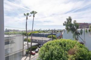 a view of a city with palm trees and buildings at Skyline Palms 1-Bedroom with Roof-Top Pool in Los Angeles