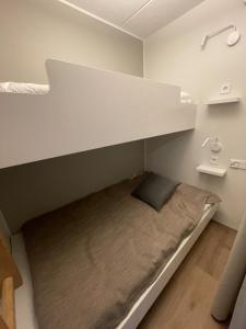 Cama en habitación pequeña con cama debajo de un estante en Ylläs chalet Bella Vista, en Ylläsjärvi