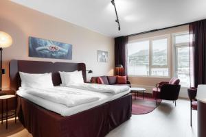 a bedroom with a bed and a living room with a couch at Scandic Sunnfjord Hotel & Spa in Førde