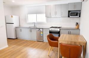 a kitchen with white appliances and a wooden table at Econo Lodge Mildura in Mildura