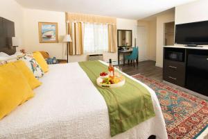 a hotel room with a bed with a bowl of fruit on it at Rodeway Inn in Middletown