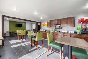 a kitchen with wooden cabinets and tables and chairs at Quality Inn in Jackson