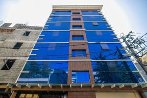 un grand bâtiment avec des fenêtres en verre bleu dans l'établissement Super Capital O Boulevard Elite Madiwala Near Ragigudda Sri Prasanna Anjanayeswamy Temple, à Bangalore