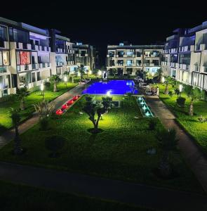 un complejo de apartamentos con piscina por la noche en Magnifique appartement de 3 chambres spacieuses vue sur piscine, en Tamaris