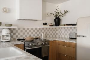 a kitchen with a stove and a sink at Ski-in/Ski-out Intentionally Designed Ski Lodge in Whistler