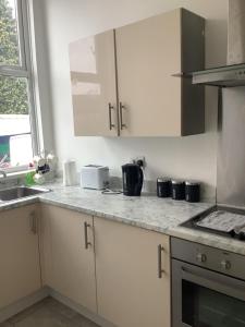 a kitchen with white cabinets and a counter top at Tiffany’s in Manchester