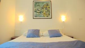a bedroom with a bed with two blue pillows at Green Oasis Family Apartments in Piran