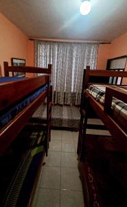 two bunk beds in a room with a window at Hostal Belén in Popayan