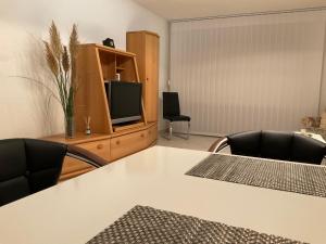uma mesa branca com cadeiras e uma televisão num quarto em Apartment Traumzeit em Bad Neustadt an der Saale