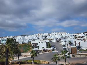 New panoramic Ocean view relaxing home Rosarito BC في Harry Manzo: الاطلالة الأمامية على مدينة بها مباني بيضاء واشجار النخيل