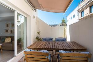 a small balcony with a wooden table and chairs at Suite Batihojas in Seville