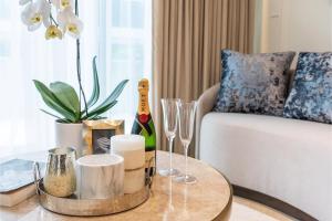 a coffee table with wine glasses and a guitar on a couch at AZUR Legacy Collection Hotel in Vancouver