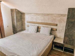 1 dormitorio con 1 cama grande y cabecero en Vila Ivan, en Berovo