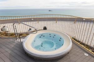 a bath tub sitting on a balcony next to the ocean at InTempo Luxury Sky View & Spa Resort in Benidorm