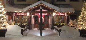 uma frente de loja com luzes de Natal na neve em Le Samovar Guest House em Breuil-Cervinia