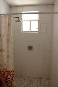La salle de bains est pourvue d'un rideau de douche et d'une fenêtre. dans l'établissement Sensity Home Recámara amplia y muy céntrica, à Tehuacán
