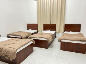 three beds in a room with a room withermottermottermott at Short Term Tourist Place in Dubai