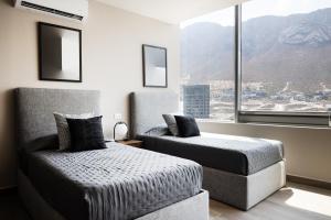 um quarto com 2 camas e uma grande janela em Amplio departamento a 3 minutos de San Pedro em Monterrey