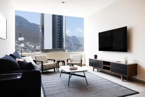 uma sala de estar com um sofá e uma televisão de ecrã plano em Amplio departamento a 3 minutos de San Pedro em Monterrey