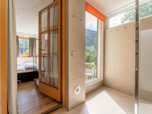 a bathroom with a glass door and a window at Hinterlengau in Saalbach-Hinterglemm