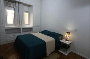 een kleine slaapkamer met een bed en een raam bij Cantinho Carioca Apto em Copacabana in Rio de Janeiro