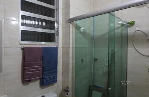 een badkamer met een glazen douche en een raam bij Cantinho Carioca Apto em Copacabana in Rio de Janeiro