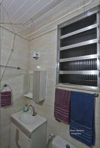 een badkamer met een wastafel, een toilet en een raam bij Cantinho Carioca Apto em Copacabana in Rio de Janeiro