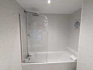 un bagno con doccia e vasca da bagno di The Senarth Guesthouse - Seaside Guesthouse with Breakfast & Free Parking a Llandudno Altre 39 foto