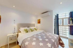 a white bedroom with a large bed and a window at Perchel Sport in Las Palmas de Gran Canaria