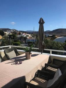 a table with a umbrella and chairs on a balcony at Perchel Sport in Las Palmas de Gran Canaria