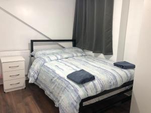 - une petite chambre avec un lit et une table de nuit dans l'établissement RAHAL OUTRAM, à Londres