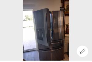 a stainless steel refrigerator in a kitchen with a window at room in residential home in Orlando