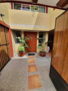 une porte ouverte d'un bâtiment avec des plantes en pot dans l'établissement Casa KOCH, à Manzanillo