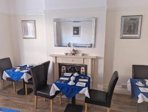 a dining room with two tables and a fireplace at The Senarth in Llandudno