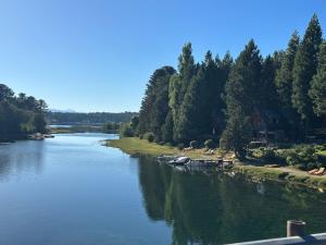 un río con árboles a su lado en Costa Bonita Cabañas en Villa Pehuenia