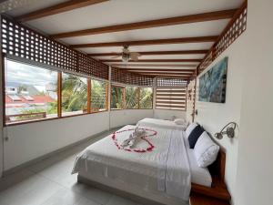 ein Schlafzimmer mit einem Bett in einem Zimmer mit Fenstern in der Unterkunft Hotel Silberstein in Puerto Ayora
