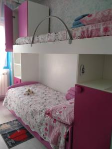 una camera con 2 letti a castello e un letto rosa di Appartamenti Centro Seriate a Seriate
