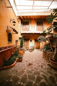 un patio con plantas y una mesa en un edificio en Hotel CasaMia en Dolores Hidalgo