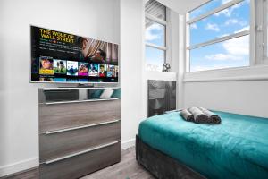 a bedroom with a flat screen tv and a bed at Luxury stay with scenic views in Brierley Hill